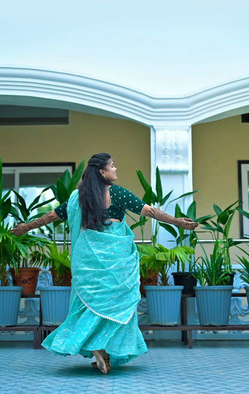 Bride twirling in a teal saree on her mehendi day