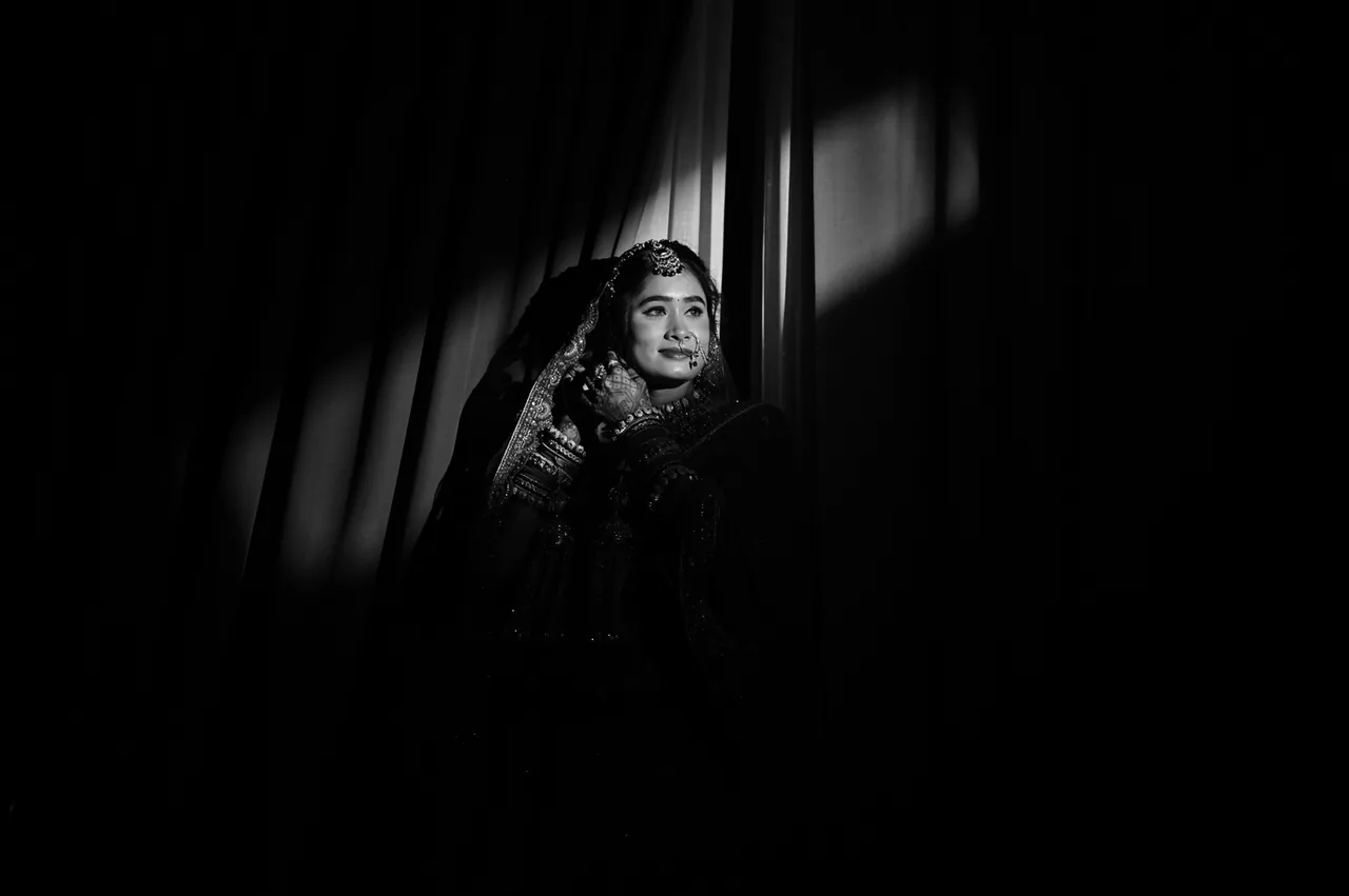 Black-and-white portrait of a bride in a beam of light