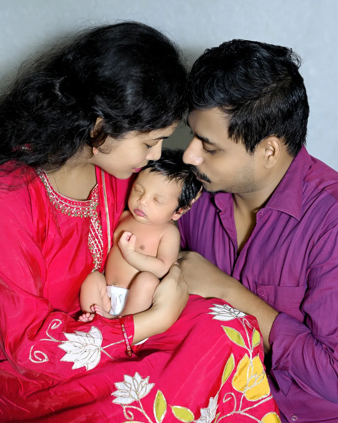 Parents holding their baby together