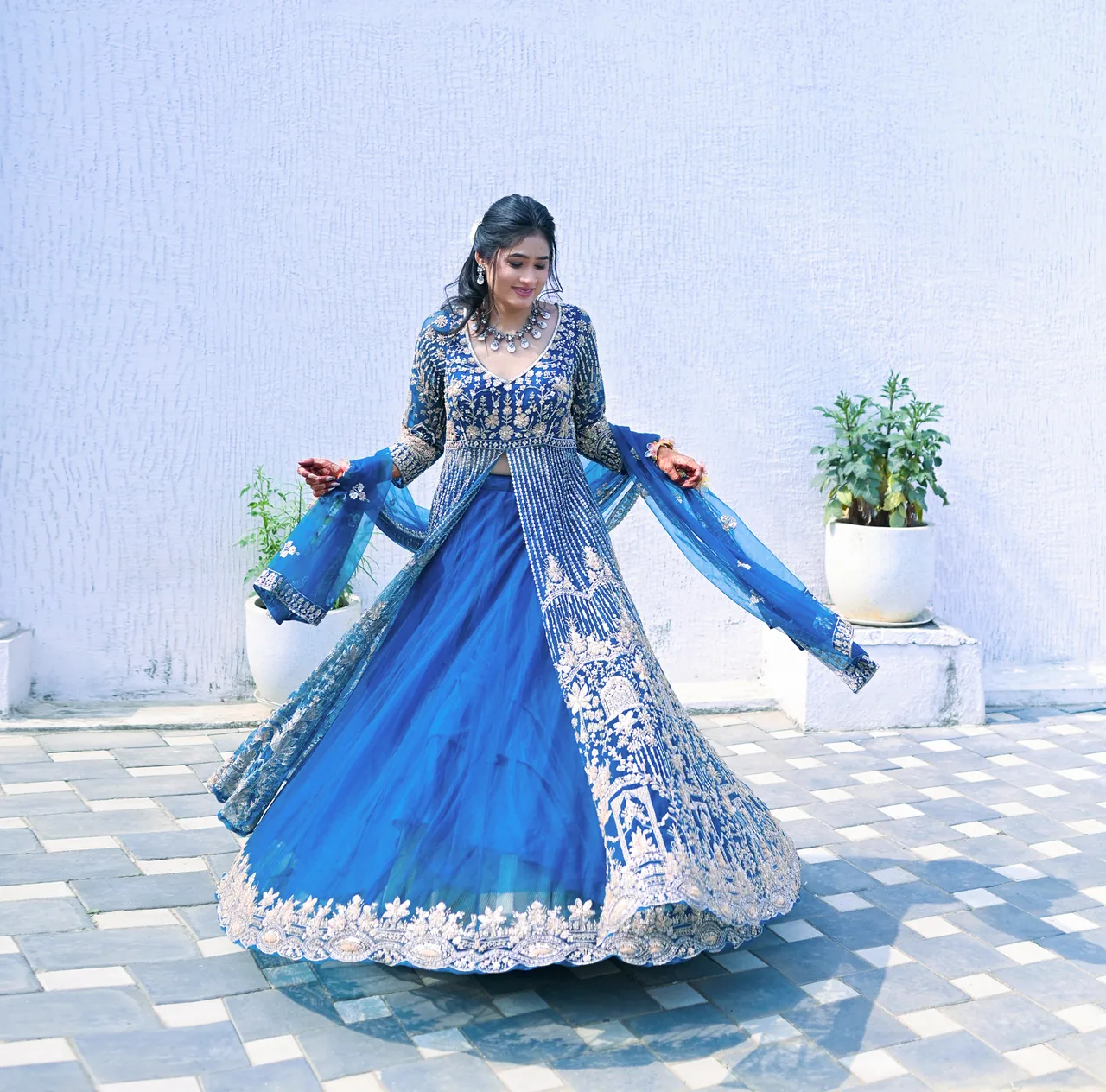 Woman twirling in a blue embroidered lehenga