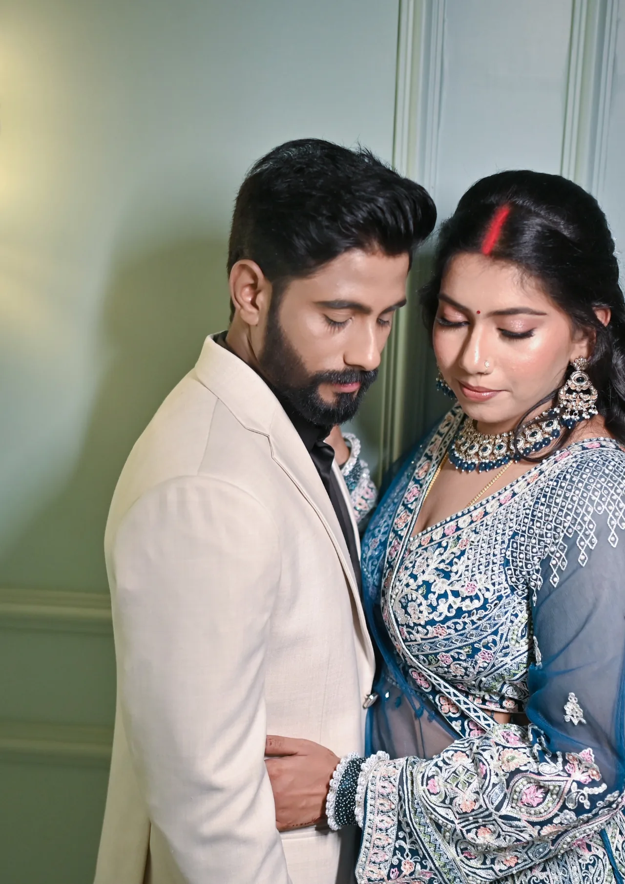 Couple in a close embrace, the bride wearing sindoor
